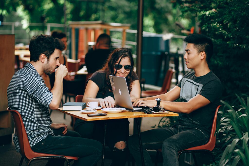 Meeting with 3 people sitting at a table outdoors
